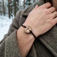 bracelet-en-bois-viking-fehu Bracelet en bois suisse au design de rune viking fehu porté par une femme en pleine nature