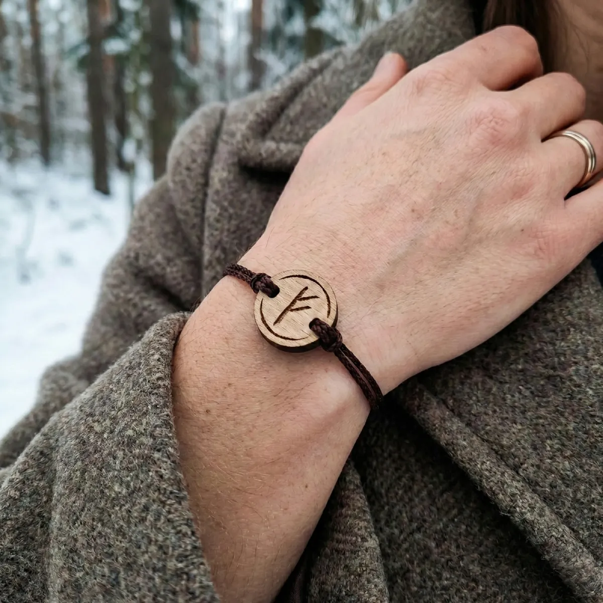 bracelet-en-bois-viking-fehu Bracelet en bois suisse au design de rune viking fehu porté par une femme en pleine nature