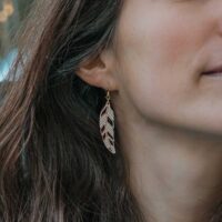 Mismatched green Piuma feather and wood earrings