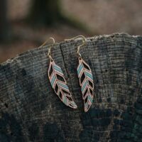 Mismatched green Piuma feather and wood earrings