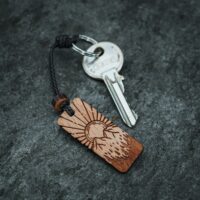 Porte clés en bois suisse avec design de paysage montagneux et soleil