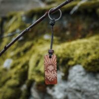 Porte clés en bois suisse avec design de paysage montagneux et soleil
