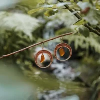 Orecchini a forma di mezzaluna realizzati in legno e vetro riciclato con un vetro marrone