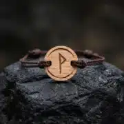 bracelet-en-bois-viking-wunjo-1 Bracelet en bois suisse au design de rune viking wunjo posé sur une roche
